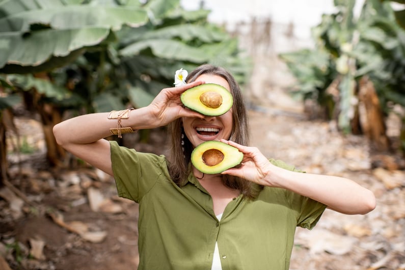 girl holding avocados