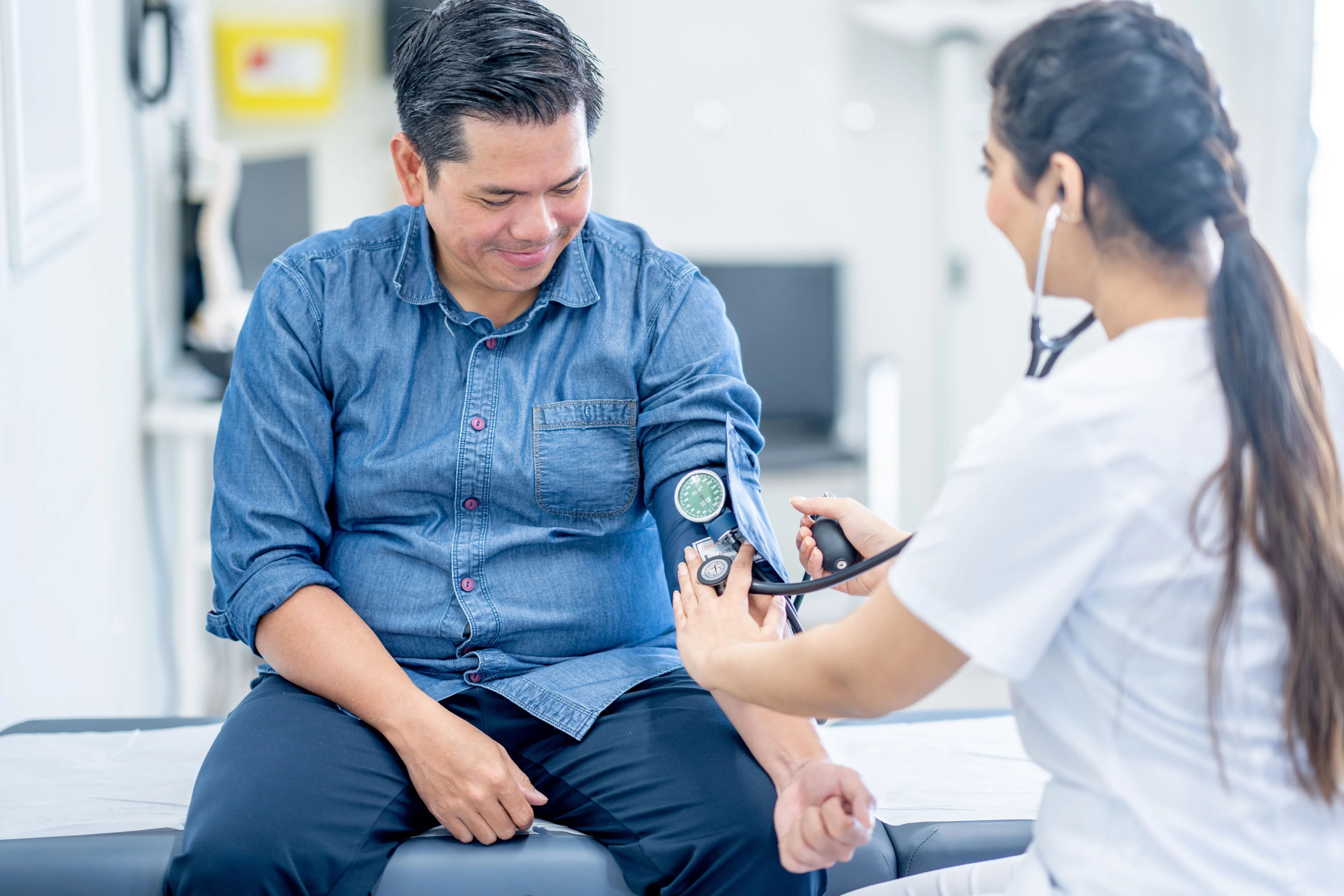 doctor checking patients blood pressure