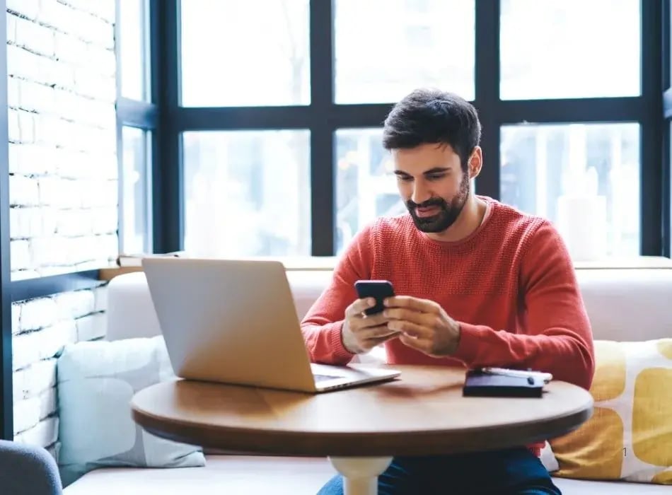 man at laptop on phone