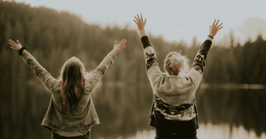 Women in nature raising hands