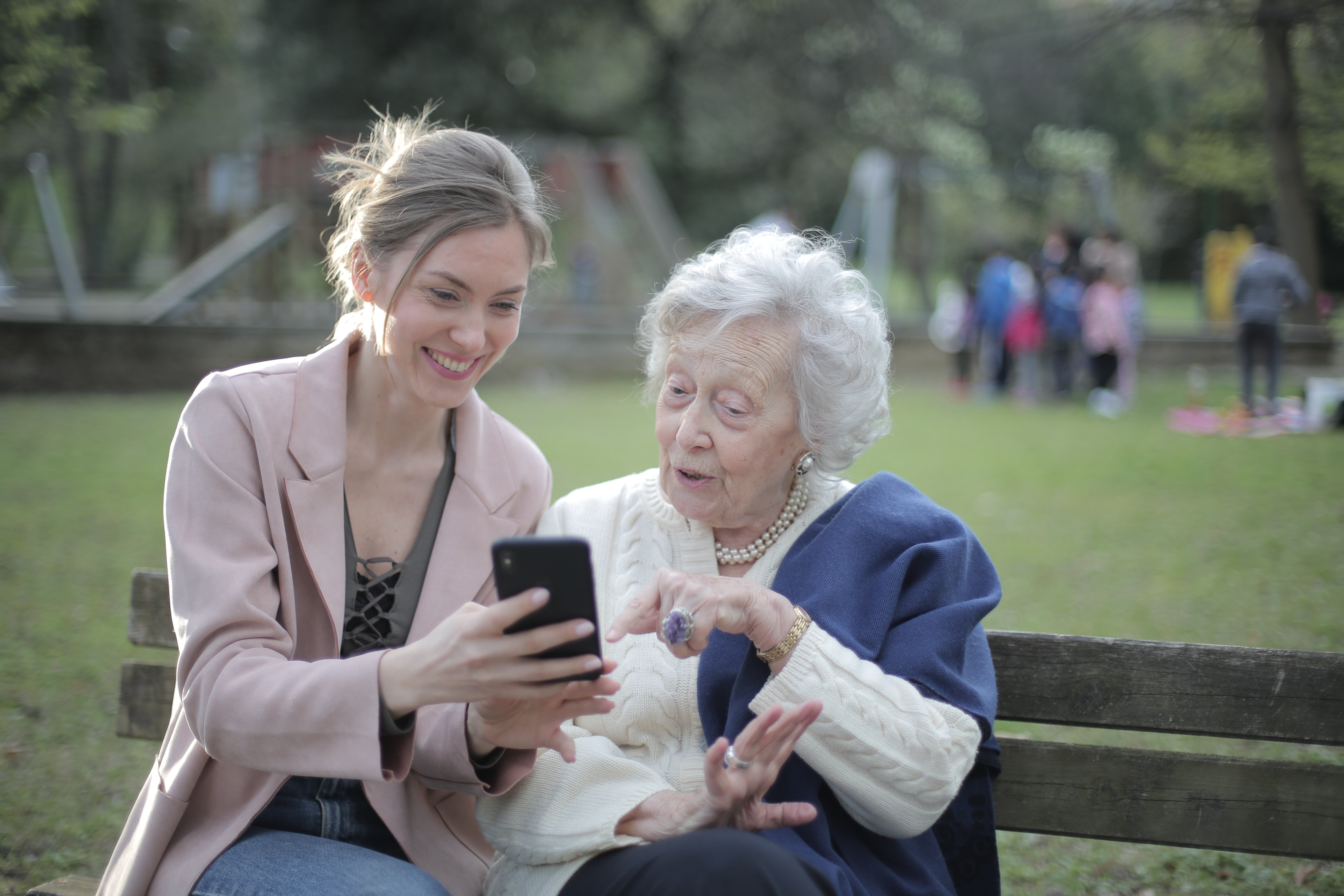 cheerful-senior-mother-and-adult-daughter-using-smartphone-3791664